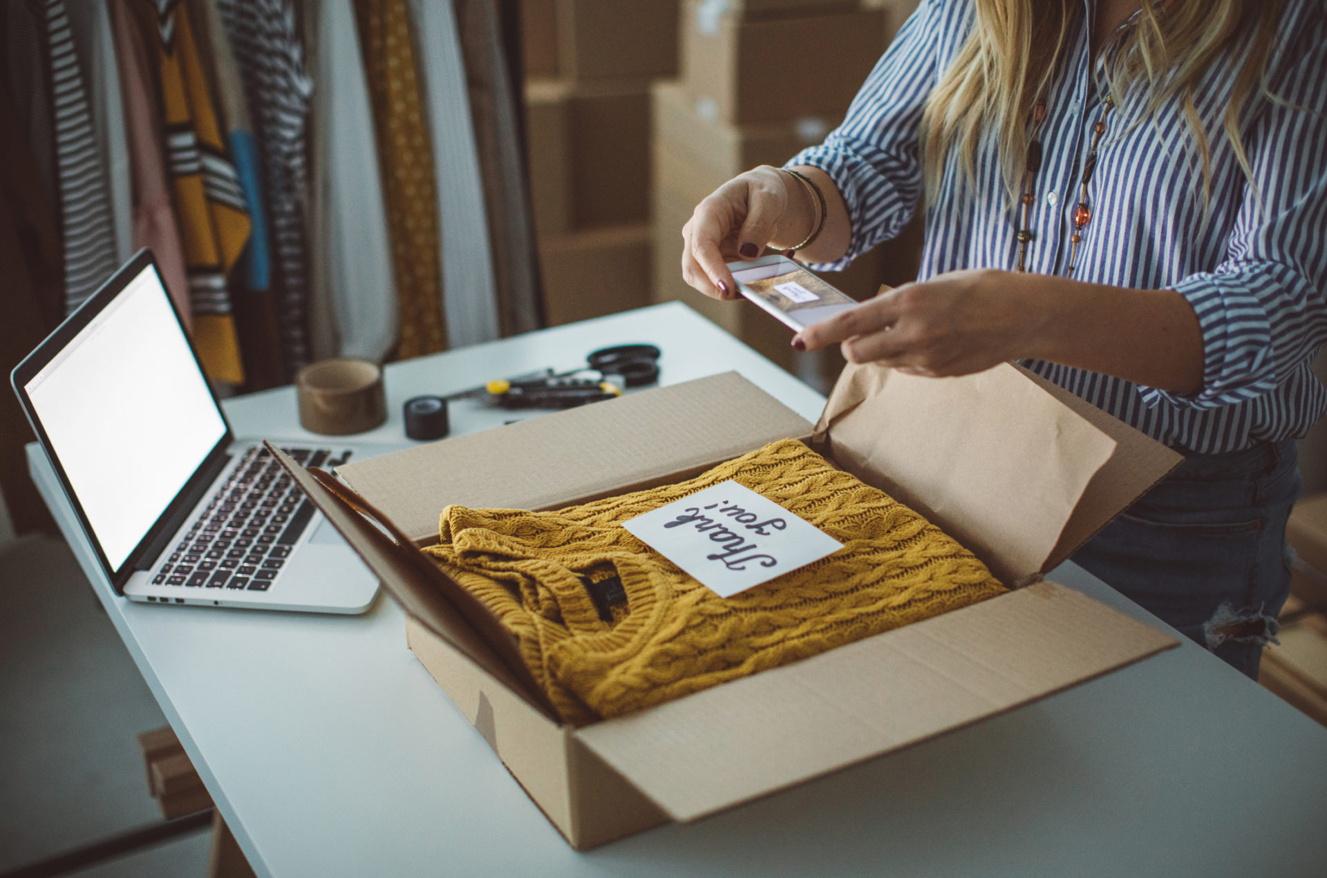 Small Business Owner Preparing A Package Using Laptop With Network Protected From Cybercrime